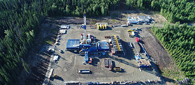 Aerial view of driling site surrounded by forest.